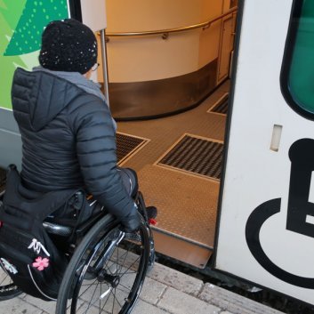 kuvassa pyörätuolia käyttävä henkilö menossa junaan