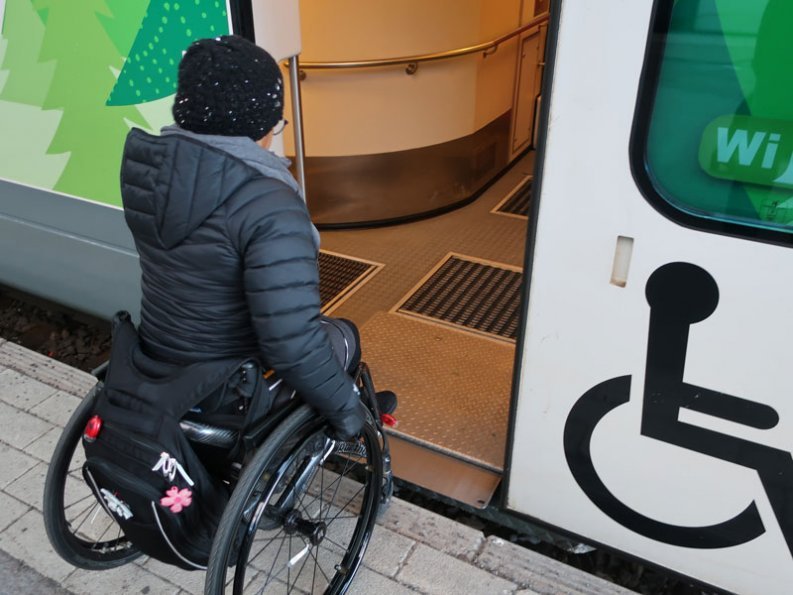 kuvassa pyörätuolia käyttävä henkilö menossa junaan